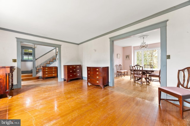 living room with hardwood / wood-style floors, ornamental molding, and a chandelier