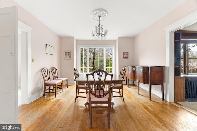 dining space featuring an inviting chandelier and light hardwood / wood-style flooring