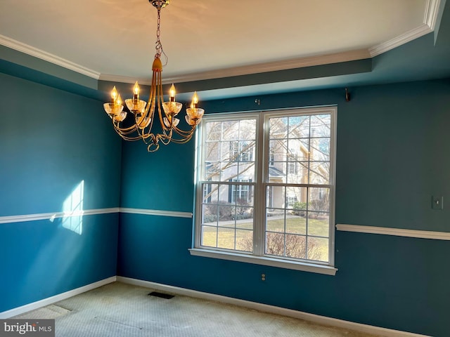 carpeted empty room featuring crown molding and a chandelier