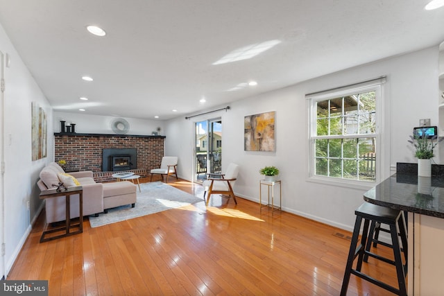 living room featuring recessed lighting, visible vents, baseboards, and light wood finished floors