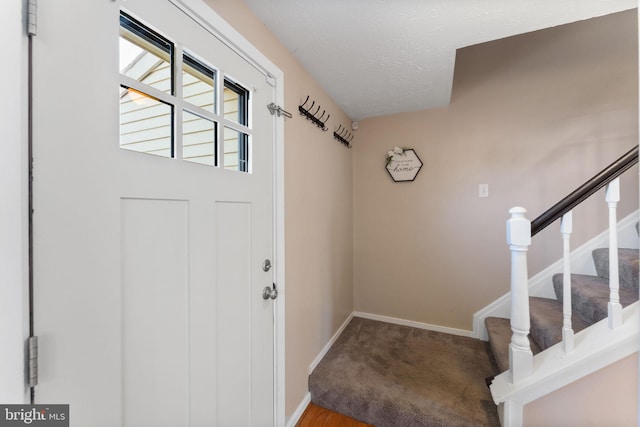 doorway to outside featuring a textured ceiling, stairs, baseboards, and carpet floors