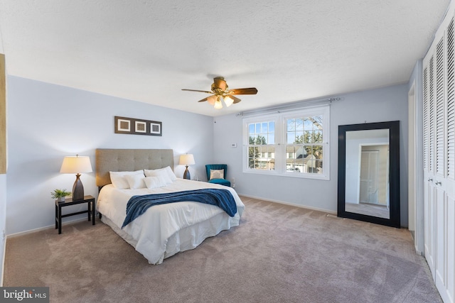 bedroom featuring baseboards, carpet, a closet, and a textured ceiling