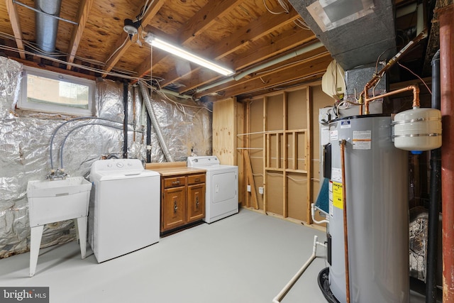 basement featuring water heater, a sink, and separate washer and dryer