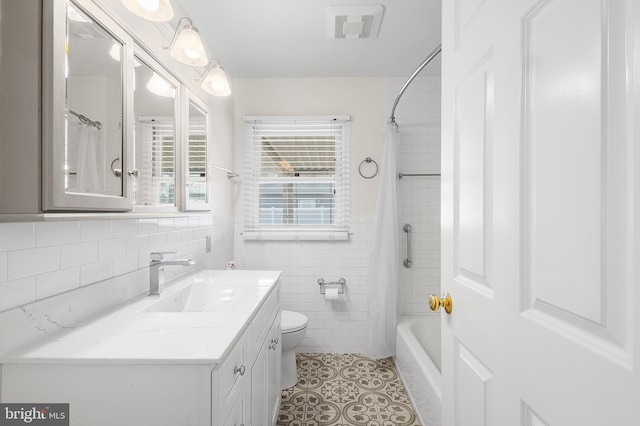 full bathroom with tile walls, vanity, shower / tub combo, toilet, and tile patterned floors