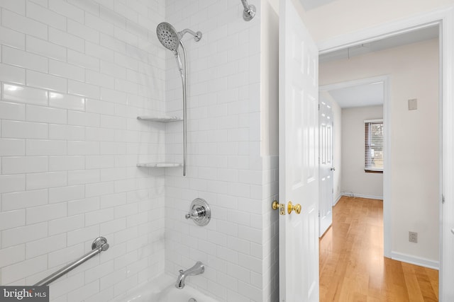 bathroom with tiled shower / bath combo and hardwood / wood-style floors