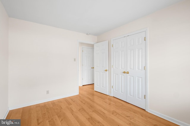 unfurnished bedroom featuring light hardwood / wood-style floors and a closet