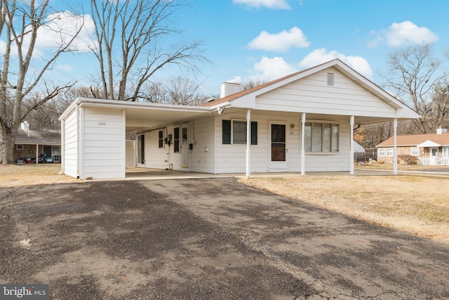 view of front of property featuring a carport and a porch