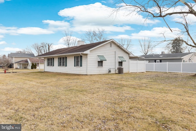 rear view of house with a yard and cooling unit