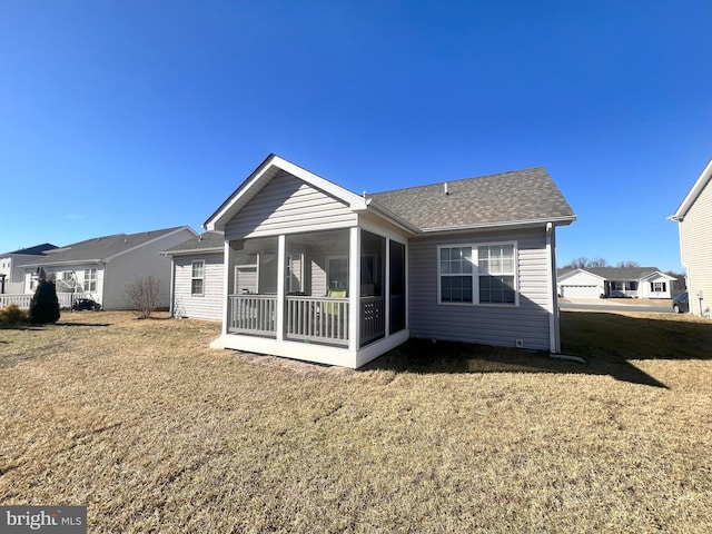 back of house featuring a sunroom and a lawn