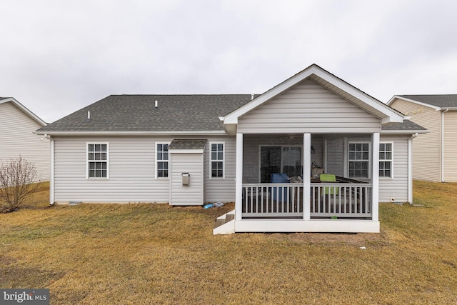 rear view of property featuring a yard and a sunroom