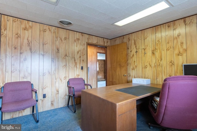 office featuring dark colored carpet and wooden walls