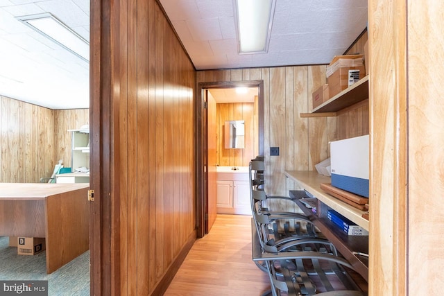 office space featuring light hardwood / wood-style flooring and wood walls