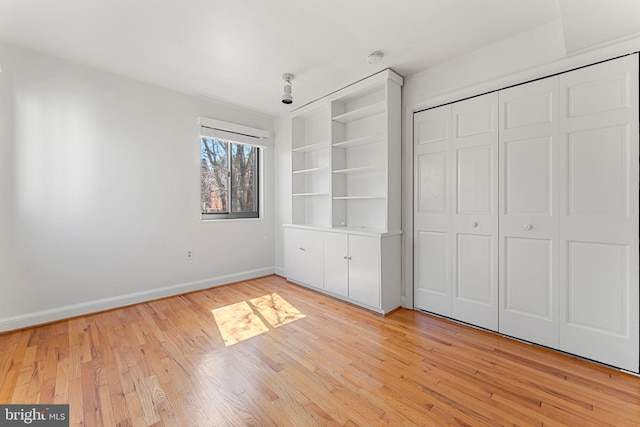 unfurnished bedroom featuring light hardwood / wood-style flooring and a closet