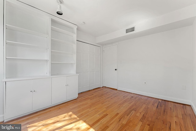 unfurnished bedroom with light hardwood / wood-style floors and a closet