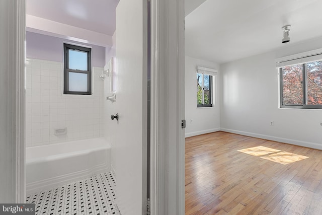 bathroom featuring tiled shower / bath combo and hardwood / wood-style floors