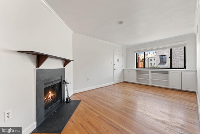 unfurnished living room featuring crown molding and light wood-type flooring