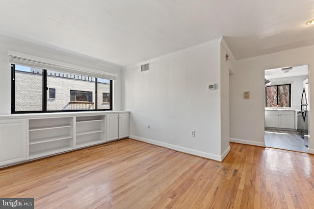 spare room featuring crown molding and light hardwood / wood-style flooring