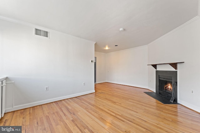 unfurnished living room featuring ornamental molding and light hardwood / wood-style floors