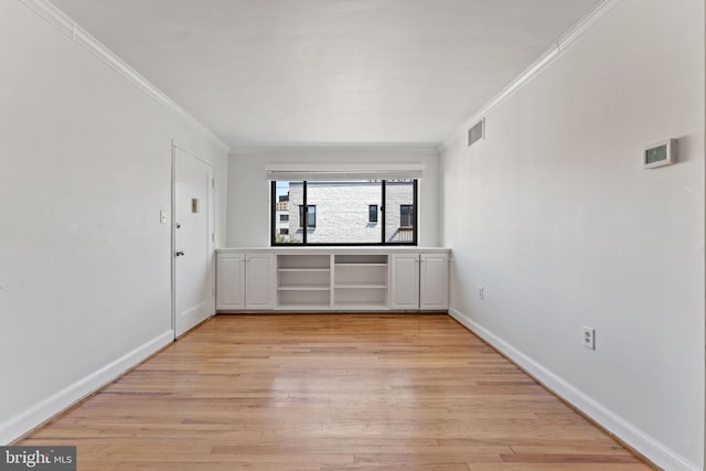 unfurnished room featuring crown molding and light hardwood / wood-style floors