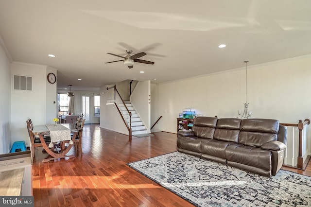 living room featuring hardwood / wood-style floors, crown molding, and ceiling fan