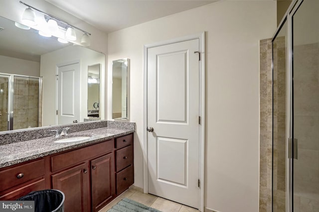 bathroom with tile patterned floors, an enclosed shower, and vanity