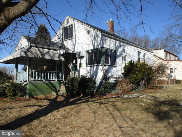 view of side of property with a porch and a yard