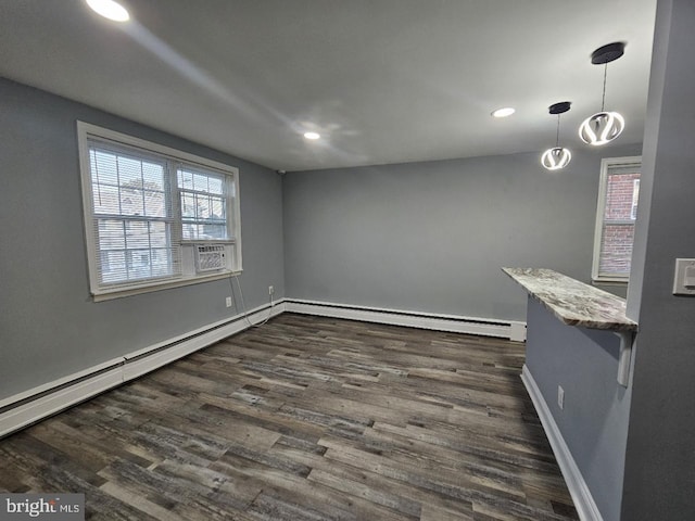 unfurnished dining area with cooling unit, a baseboard radiator, and dark hardwood / wood-style floors