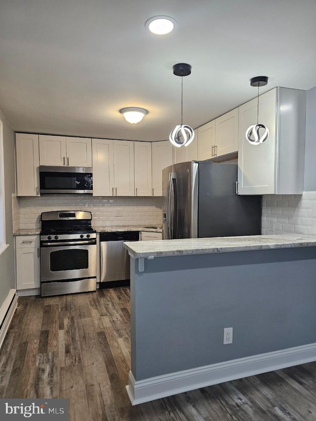 kitchen featuring pendant lighting, white cabinets, and appliances with stainless steel finishes