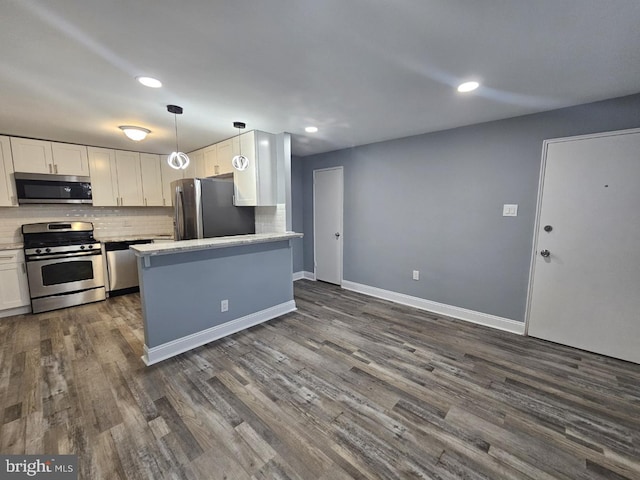 kitchen featuring white cabinetry, pendant lighting, dark hardwood / wood-style floors, and appliances with stainless steel finishes