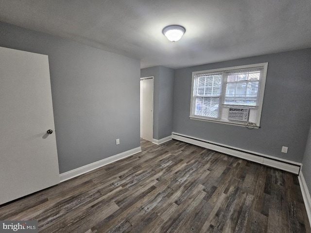 spare room with cooling unit, dark hardwood / wood-style flooring, and a baseboard heating unit