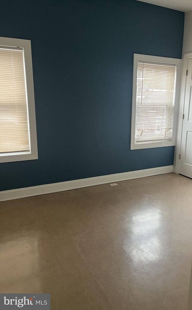 unfurnished room with concrete flooring