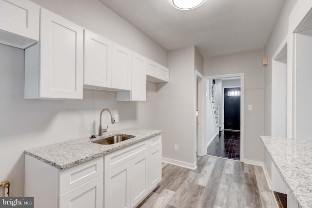 127 Cherrydell, Catonsville, MD 21228 - kitchen with light stone counters, light wood-style floors, white cabinets, a sink, and baseboards