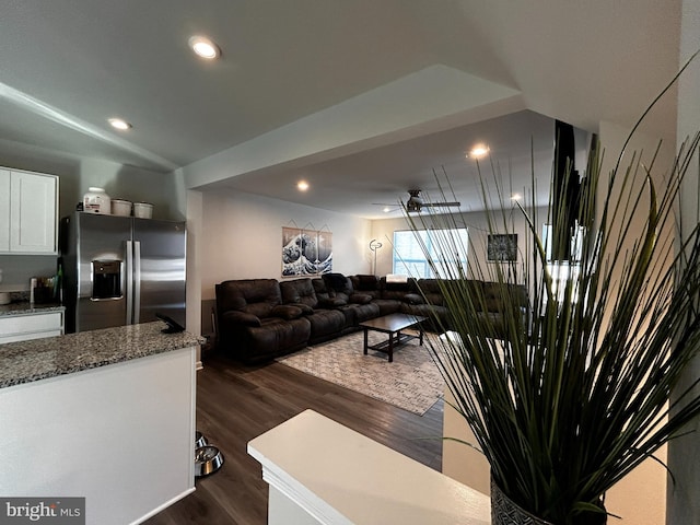 living room featuring dark wood-type flooring and ceiling fan