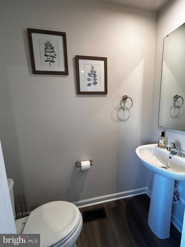 bathroom featuring wood-type flooring, sink, and toilet