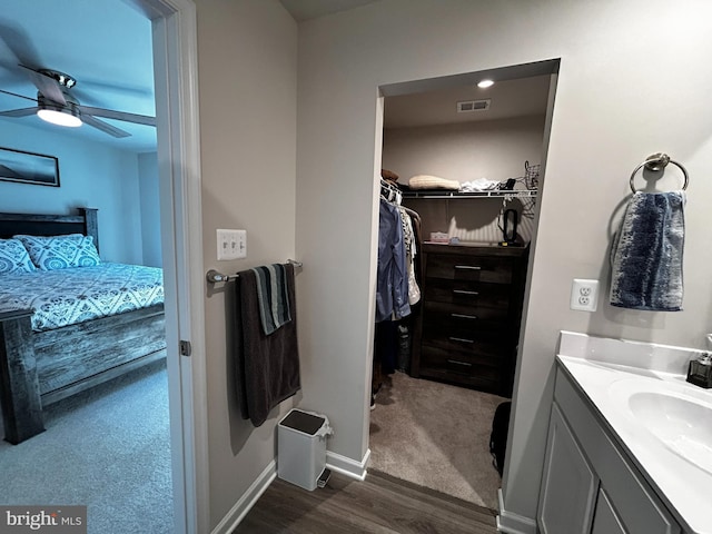 bathroom with ceiling fan, vanity, and wood-type flooring