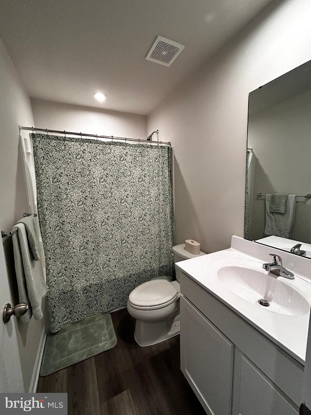 bathroom with vanity, hardwood / wood-style flooring, and toilet