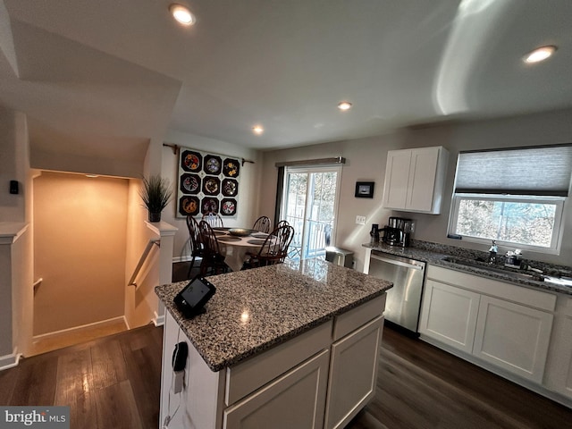 kitchen featuring sink, stone countertops, stainless steel dishwasher, a kitchen island, and white cabinets