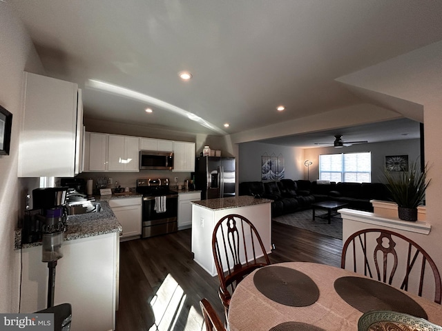 dining area with ceiling fan, lofted ceiling, sink, and dark hardwood / wood-style flooring