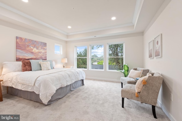 bedroom with crown molding, light colored carpet, and a tray ceiling