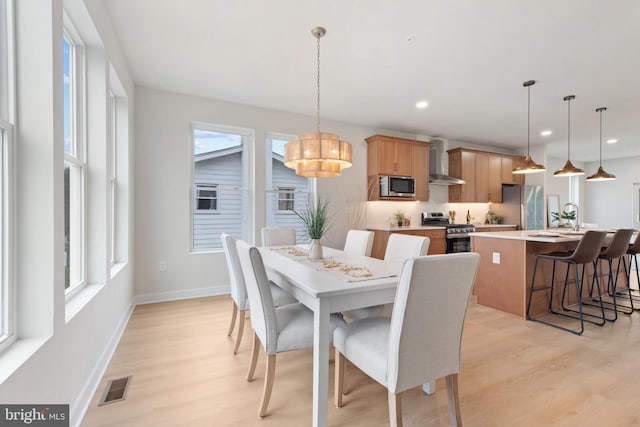 dining space featuring sink and light hardwood / wood-style floors