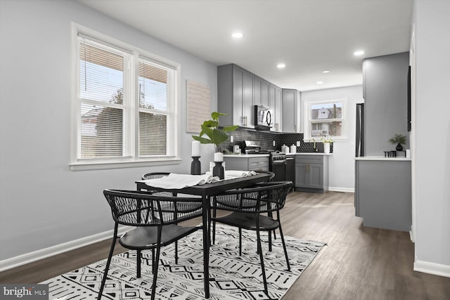 dining room with sink and dark wood-type flooring