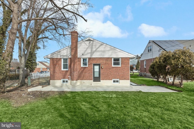 rear view of property with a patio and a lawn