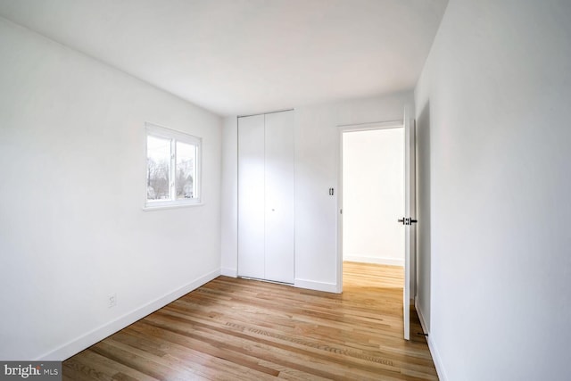 unfurnished bedroom featuring light hardwood / wood-style floors and a closet