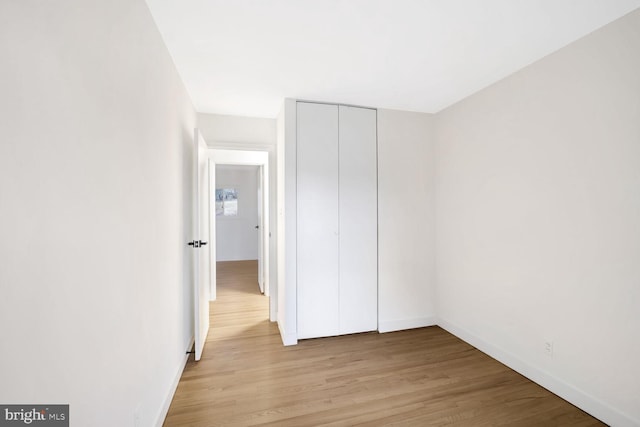 unfurnished bedroom with light hardwood / wood-style floors and a closet