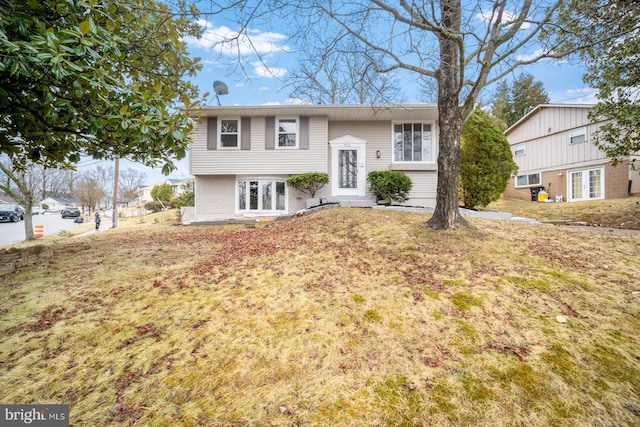 bi-level home with a front lawn and french doors