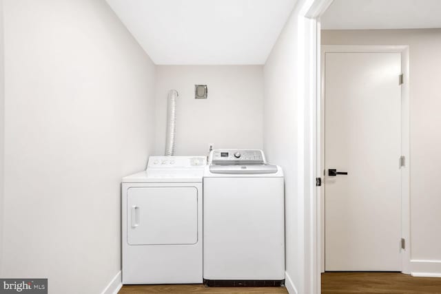 clothes washing area with wood-type flooring and washer and clothes dryer