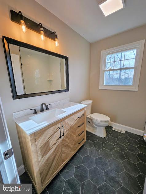 bathroom with vanity, tile patterned flooring, and toilet