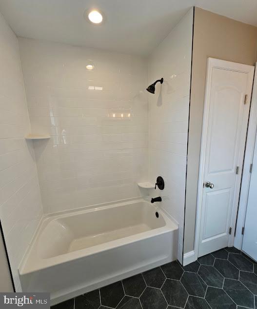 bathroom featuring tile patterned flooring and tiled shower / bath