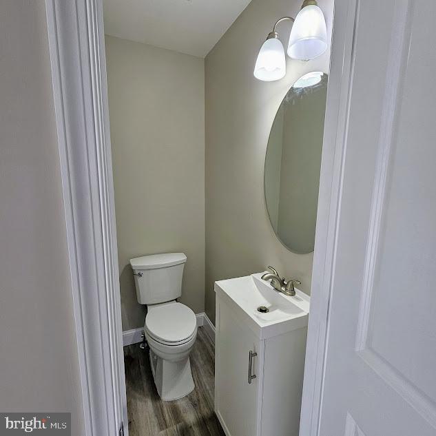 bathroom with vanity, toilet, and hardwood / wood-style floors