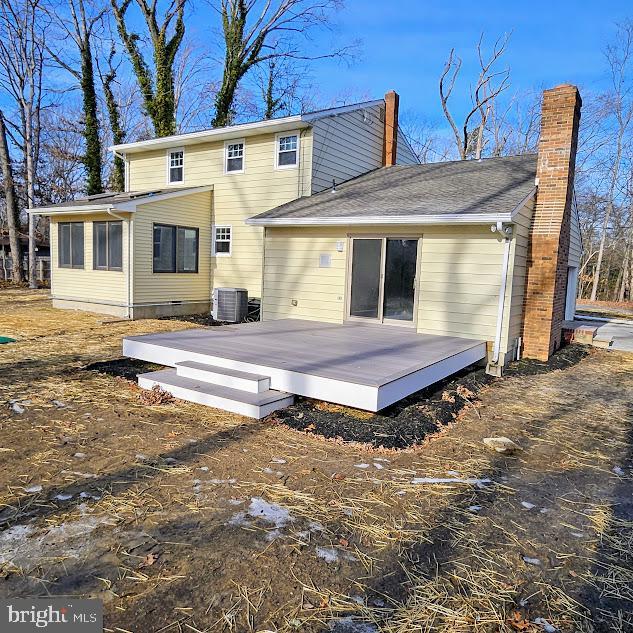 rear view of property with cooling unit and a wooden deck